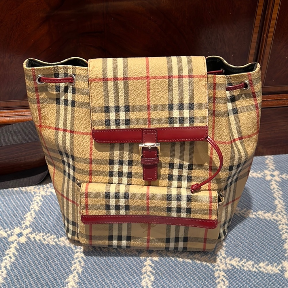 Burberry Backpack. Iconic Burberry print with red leather accents.